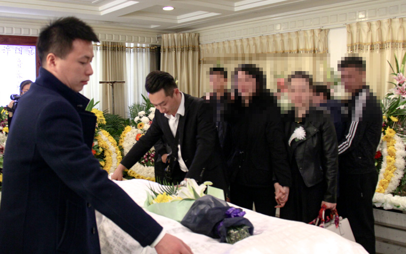 服务专员在告别厅为亲人整理 服务专员在告别厅为亲人整理